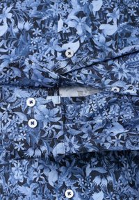 Bloemmotief overhemd in tinten blauw, gemaakt van stof met een gladde textuur; voorzien van knoopsluiting en een borstzak.