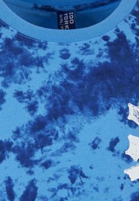 Blå bomulls T-skjorte med tie-dye mønster. Rund hals-design med varierende nyanser av blått og hvite aksenter. Myk tekstur og uformell stil.