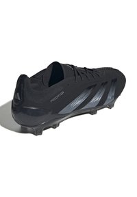 Zwarte voetbalschoenen met een slank ontwerp, voorzien van glanzend zwarte accenten en metallic grijze strepen. Gestructureerde bovenkant en gemodelleerde noppen voor grip.