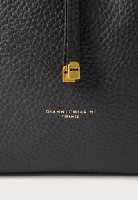 Fekete bőr kézitáska texturált felülettel, arany tónusú cipzárhúzóval és a márka logójával, amely arany színben van az alján dombornyomva.