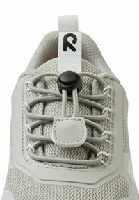 Jasnoszary but sportowy z siateczkową cholewką, elastycznymi sznurówkami, okrągłym zapięciem oraz teksturowaną gumową podeszwą.