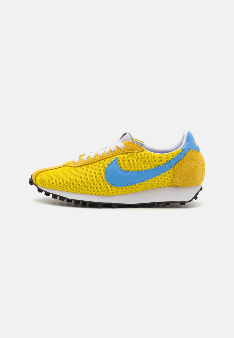 Sárga hálós sneaker kék kiegészítőkkel, fehér fűzőkkel és texturált sárga velúr sarokkal. Feketére festett gumi talp, tapadásmintával.