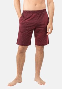 Shorts bordeaux avec un motif de petits points blancs subtils, fabriqués dans un tissu doux, dotés d'une taille élastique et de poches latérales.