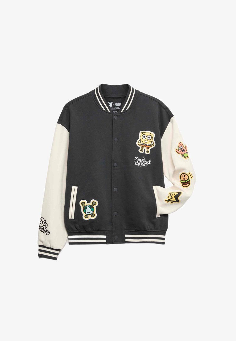 černá a smetanová varsity bunda se zábavnými nášivkami, žebrovanými manžetami a límcem, předními kapsami a dvoubarevnými rukávy.