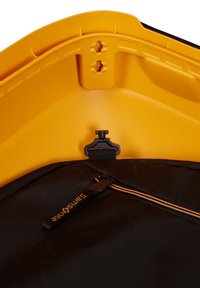 Schwarze Duffel-Tasche mit strukturiertem Finish, ausgestattet mit einem orangefarbenen Reißverschluss und Beschlägen. Gelber, geformter oberer Abschnitt mit glatter Oberfläche und Befestigungspunkten.