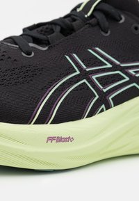 Zapatilla deportiva negra con parte superior transpirable, con detalles en verde claro y morado. Suela texturizada con el detalle "FF Blast+".