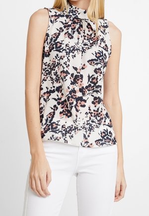Mouwloze blouse van lichtgewicht stof met een bloemenpatroon in roze en marineblauw op een crèmekleurige achtergrond, met een hoge halslijn en plooien.
