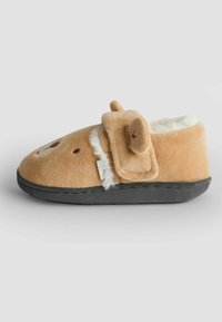 Tan plyschtoffel med en mjuk vit foder, försedda med ett björndesign, runda öron och en svart gummisula. Justerbart kardborreband.