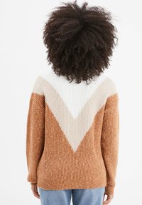 Strickpullover mit strukturiertem Muster und einem V-förmigen Farbblockdesign in Braun, Creme und Weiß. Lange Ärmel und eine lässige Passform.