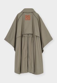 Poncho de pluie kaki avec larges manches, détail rabat au dos et un patch logo carré en cuir marron sous le col.