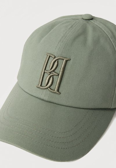 Καπέλο μπέιζμπολ σε ελιά χρώμα με καμπύλη γείσο και κεντημένο λογότυπο διπλού γράμματος πλεγμένο στην μπροστινή πλευρά.