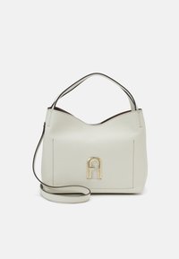 Krämfärgad läderhandväska med detaljer i guld, som har ett ensamt handtag och en justerbar axelrem. Slät textur.