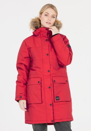 Rød isoleret parka med høj krave, faux fur hætte, trykknapper, to frontlommer og sorte accenter på ærmerne og logoet.