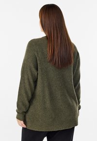 Oliivinvihreä neulepusero, jossa on rento istuvuus, ribbikuviointi ja pitkät hihat. Takana helma on hieman pidempi.