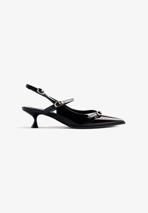 Scarpa slingback in vernice nera con punta affusolata, tacco cone basso e cinturino alla caviglia regolabile con dettagli a fibbia circolare.