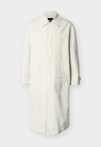 Μακρύ εκρού παλτό τύπου τρεντς με γιακά, κρυφό κούμπωμα με κουμπιά, πλαϊνές τσέπες και μανσέτες με κουμπιά, παρουσιασμένο σε απλό ανοιχτό γκρι φόντο.