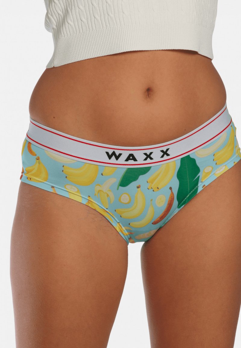 Sous-vêtements bleus avec un motif répété de bananes et de feuilles. Ceinture élastique rouge et blanche avec le logo "WAXX". Matière en coton.