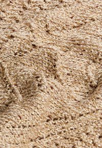 Beige geweven stof met een zachte, gebreide uitstraling, verweven met metallic gouden draden, wat een subtiele glans creëert.