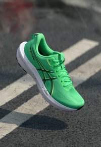 Grüner Sportschuh mit einem strukturierten Mesh-Obermaterial, das schwarze Akzente und Schnürsenkel aufweist, sowie einer weißen Sohle mit "FF Blast"-Markierung.