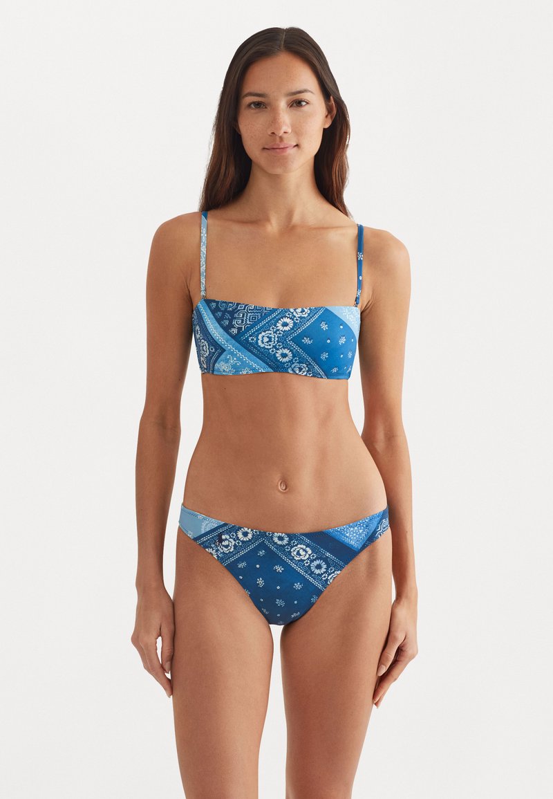 Blue bikini set featuring a bandeau top with adjustable straps and a matching bottom. The fabric displays a bandana pattern in varying shades of blue.