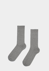 Graue Baumwollsocken mit feiner Stricktextur, in Knöchelhöhe, glattem Bündchen und verstärkten Fersen- und Zehenbereichen für Langlebigkeit.