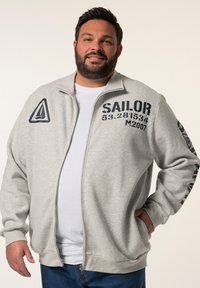 Sudadera gris con cremallera y estampado en azul marino, que presenta un logo de velero, texto "SAILOR" y detalles numéricos en la parte delantera y la manga.