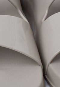 Infradito beige con cinturini lucidi e lisci e solette texture. Il design presenta cinturini larghi che si sovrappongono al centro.
