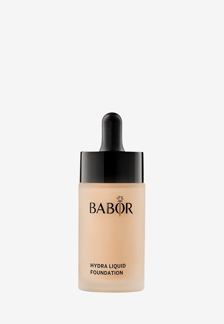Fondotinta Babor Hydra in una bottiglia di vetro satinato traslucido con un tappo contagocce nero e il logo. Superficie liscia con una sfumatura beige neutra.