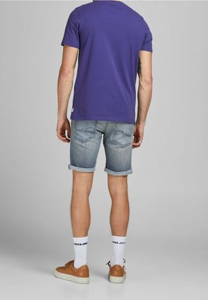 Paarse katoen t-shirt, spijkerbroekshorts met omgeslagen randen, witte sokken met logo en bruine sneakers. Standaard pasvorm met een casual ontwerp.