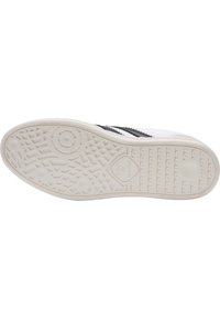 Vit sneakersula med texturerad gummi, med ett cirkulärt och linjärt mönster. Svarta accenter längs sidan, med logotyp i mitten.