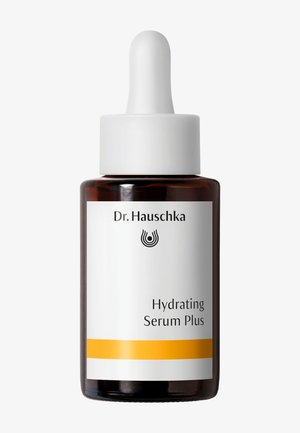 Flacon compte-gouttes en verre brun étiqueté Dr. Hauschka Hydrating Serum Plus avec bouchon blanc et bande jaune sur l’étiquette sur fond blanc.