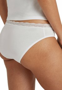 Witte katoenen onderbroek met een kant afgewerkte tailleband, voorzien van een soepele textuur en een ontwerp met volledige dekking aan de achterkant.
