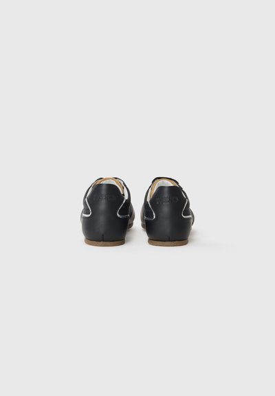 Black leather shoes with a rounded design, featuring white stitching and a textured outsole. The brand name is embossed on the heel.