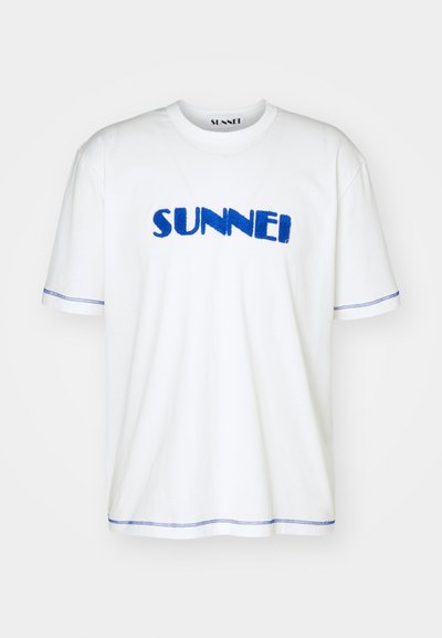 Λευκό βαμβακερό T-shirt με μπλε κεντητό λογότυπο "SUNNEI", κοντά μανίκια και μπλε ραφές γύρω από τα μανίκια και το στρίφωμα.