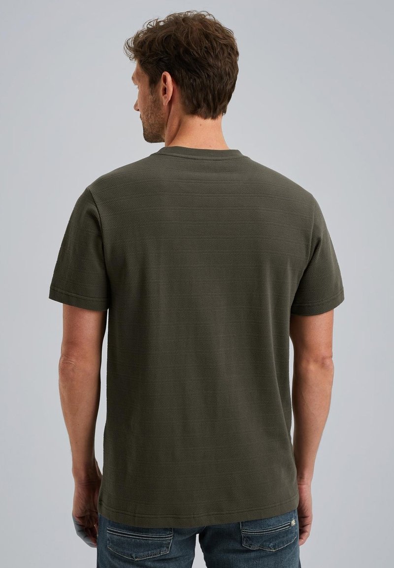 T-shirt a maniche corte di colore verde oliva realizzato in tessuto texture. Presenta un colletto arrotondato e una vestibilità regolare, indossato con jeans blu.
