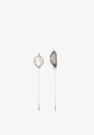 Orecchini minimalisti color argento caratterizzati da una forma rotonda liscia e un accento di pietra irregolare e texturizzata; ciascuno pende da un filo sottile.