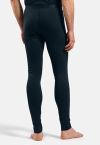 Black leggings made from stretchable material, featuring a slim fit and ankle cuffs. Visible stitching along the seams for added detail.