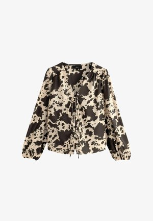 Blúzka s dlhým rukávom v krémovej a čiernej farbe s motívom kravy. Obsahuje hlboký výstrih do V so zaväzovaním vpredu a nariasené rukávy s elastickými manžetami.