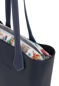 Laavyninen olkalaukku, jossa on farkkukahvat, varustettuna vetoketjullisella sisäosastolla, jossa on värikäs simpukkakuosi valkoisella taustalla.