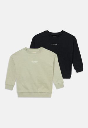 Deux sweatshirts à manches longues et col rond, un vert clair et un noir, chacun avec un petit texte blanc "Crafted Goods Youth Apparel" sur la poitrine.