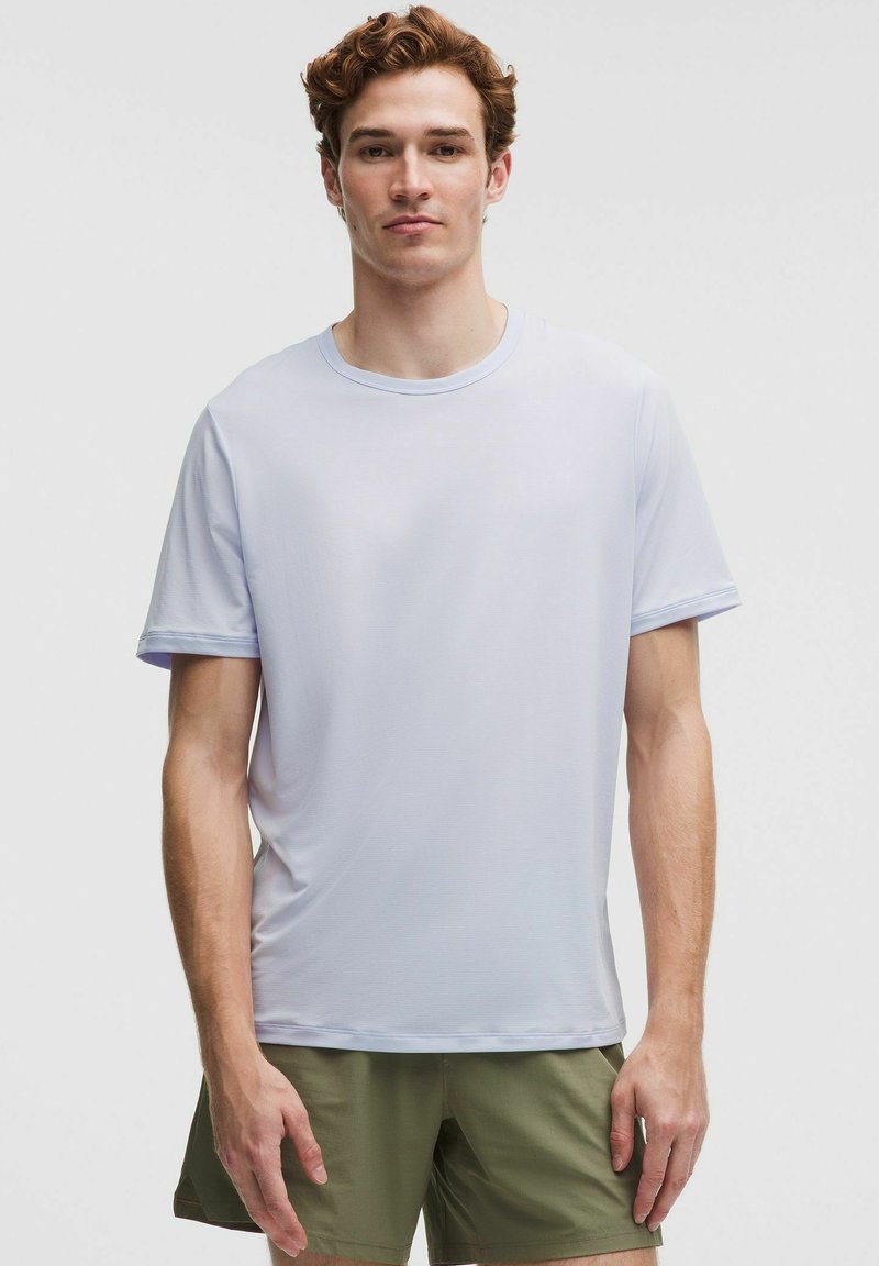Helderblauw sport T-shirt met korte mouwen van lichtgewicht stof. Het heeft een ronde hals en een gladde textuur met minimale naden.