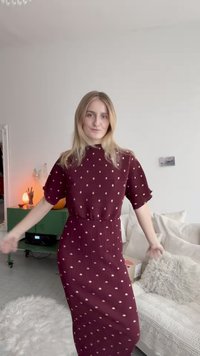 Mauve színű, térdmedi hosszúságú ruha rövid ujjakkal, bordázott textúrával és arany pöttyös mintával. Feszes derék, lágyan hullámzó szoknya és laza sziluett.