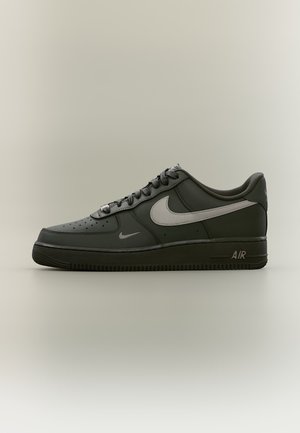 Μαύρο αθλητικό παπούτσι Nike Air Force 1 με σόλα σκούρου γκρι και μεγάλο ανοιχτό γκρι λογότυπο Nike στη πλευρά, εμφανιζόμενο από δεξιά προφίλ.