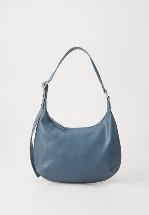 Sininen nahkakäsilaukku pyöreällä muotoilulla, yhdellä olkahihnalla, vetoketjukiinnityksellä ja kohokuvioidulla brändinimellä edessä. Sileä pinta.