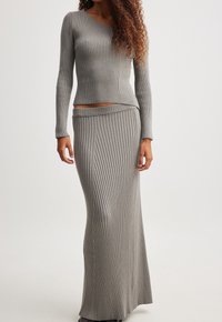 Robe deux pièces à mailles côtelées grises, comprenant un haut ajusté à manches longues et une jupe droite longueur sol à taille haute.