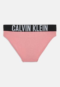 Rózsaszín pamut alsónemű fekete derékvonallal, melyen fehér "CALVIN KLEIN" felirat látható. Egyszerű dizájn, sima textúra, klasszikus alacsony derekú fazon.