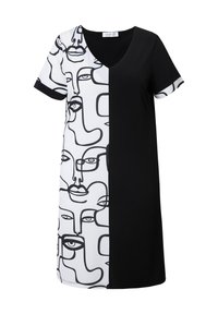 Robe en noir et blanc avec un col en V, des manches courtes et un motif de visage abstrait d'un côté, tandis que l'autre côté est entièrement noir.