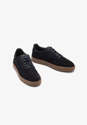 Baskets en suédine bleu marine avec semelles en caoutchouc marron, dotées d'un design à lacets et de lacets gris contrastants, logo embossé sur le côté.