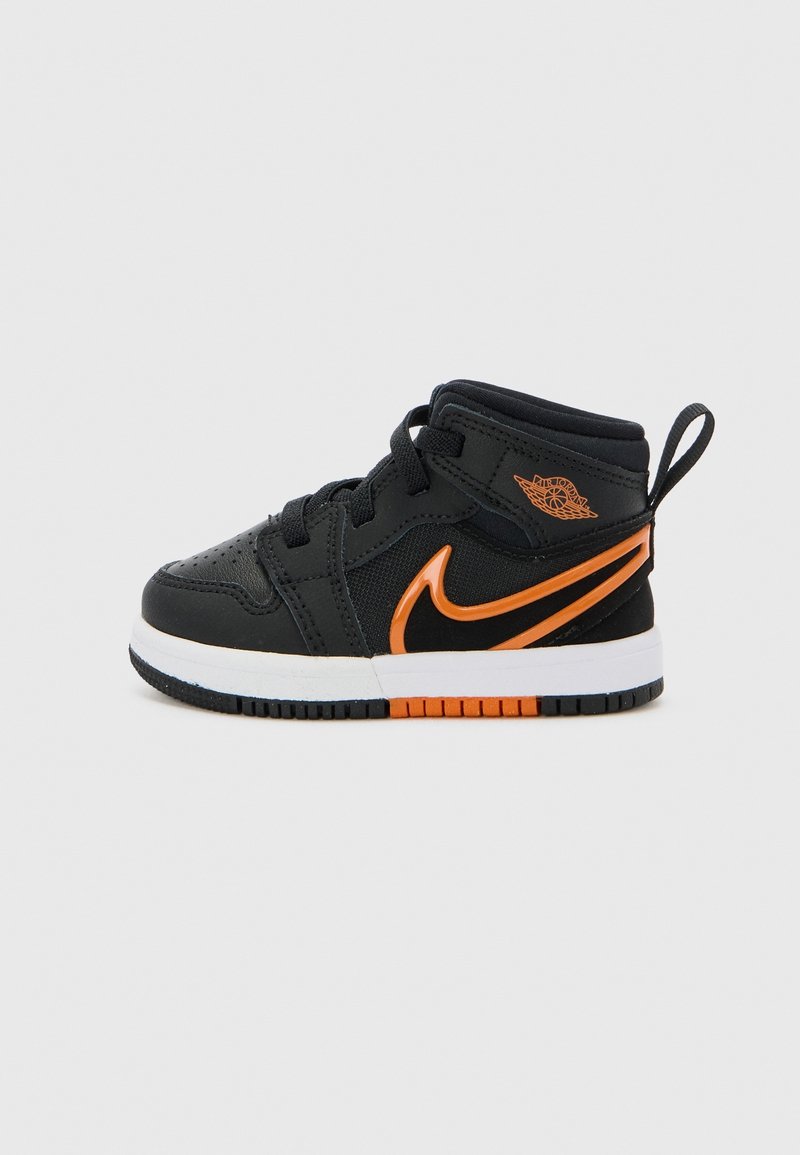 Baskets Nike Air Jordan bébé noires et oranges avec lacets, hautes, et semelle blanche avec des accents orange et noir sur la bande de roulement.