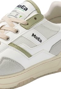 Witte sneaker met groene accenten, textured mesh en faux suede. Voorzien van 'MoEa' logo, beige veters en een dikke, lichtgekleurde zool.